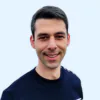Portrait d'un homme souriant portant un pull bleu marine