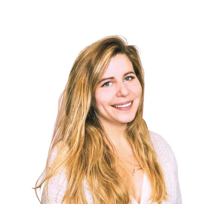 Femme souriante aux longs cheveux blonds portant un haut blanc