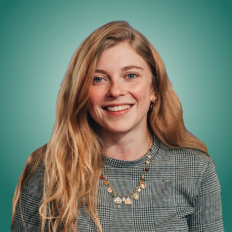Portrait d'une femme souriante aux cheveux longs blonds sur fond vert